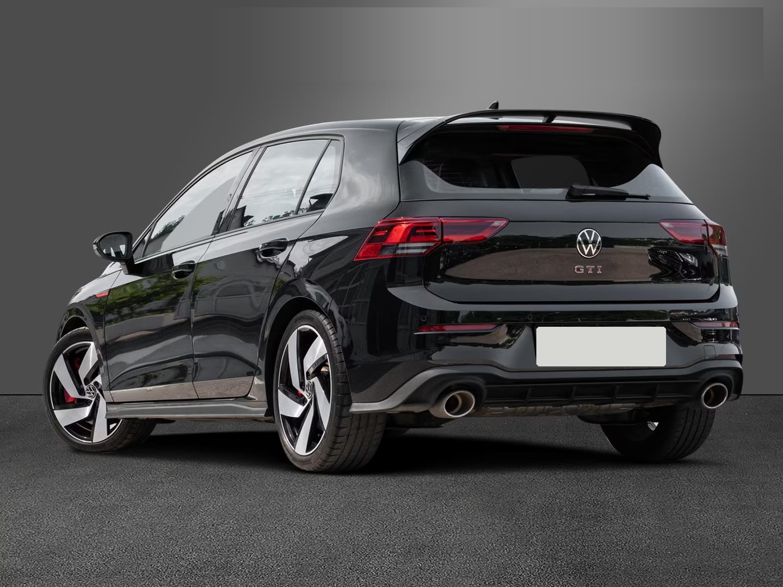 Rear three-quarter view of the black Golf GTI Clubsport with roof spoiler and twin exhausts.