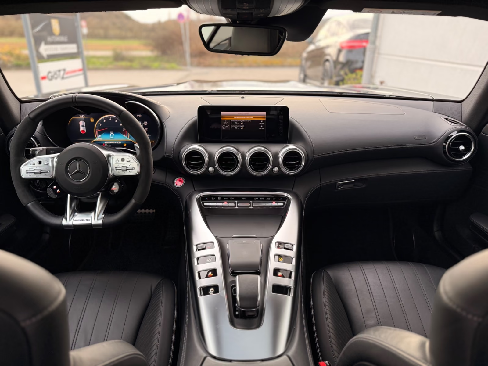 Interior of the Mercedes-AMG GT C showing the AMG steering wheel, digital cockpit, central display and turbine air vents.