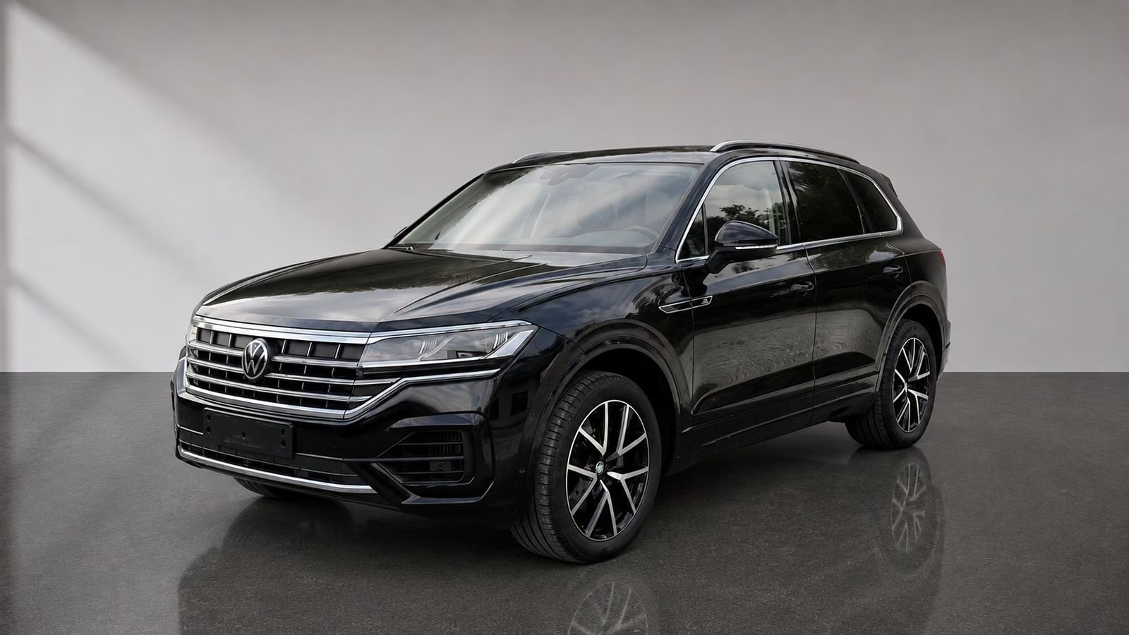 Volkswagen Touareg R-Line in Deep Black pearl effect, front three-quarter view with black gloss-turned 20-inch wheels.