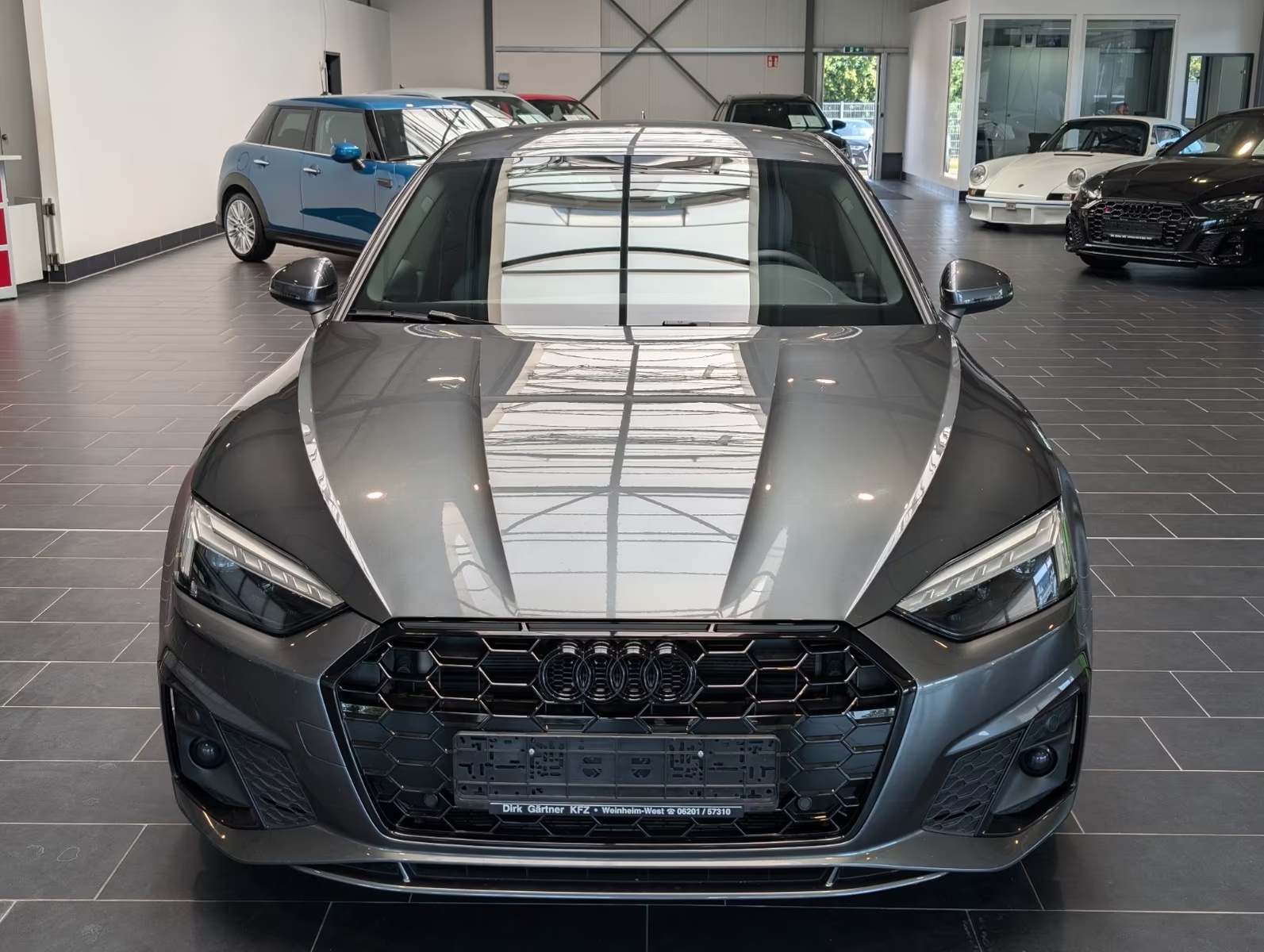 Front view of the grey metallic Audi A5 Sportback showing the single-frame grille, LED headlights and front bumper.