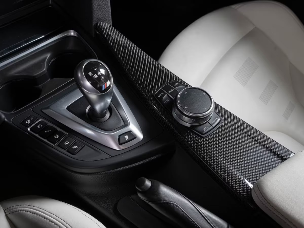 Carbon centre console of the BMW M4 with the M double-clutch gear selector and iDrive controller.