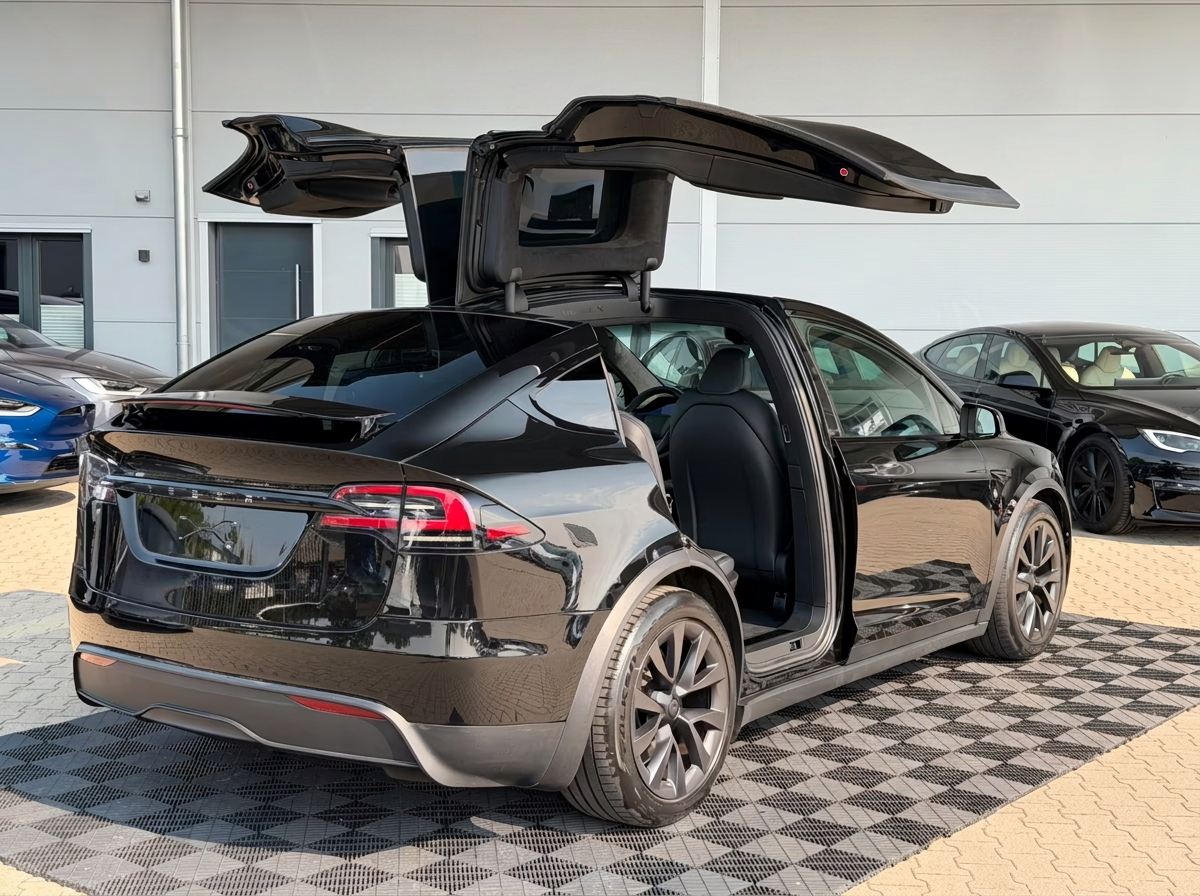 Rear three-quarter view of the black Tesla Model X on 20-inch Cyberstream wheels.