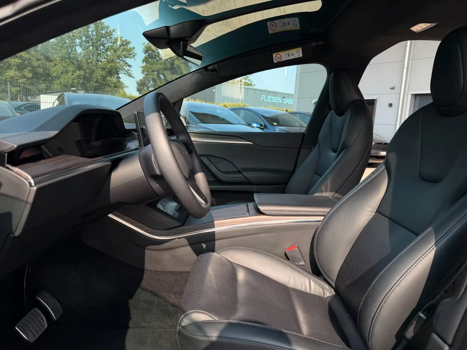 Front cabin of the Tesla Model X with black leather seats and steering wheel.