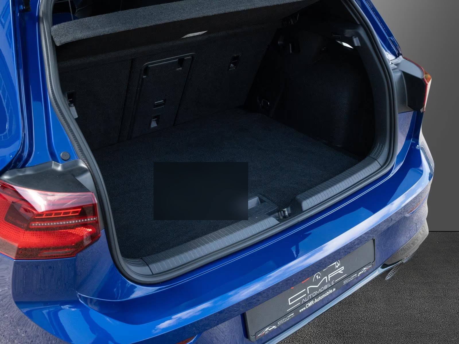 Open luggage compartment of the blue Volkswagen Golf R.