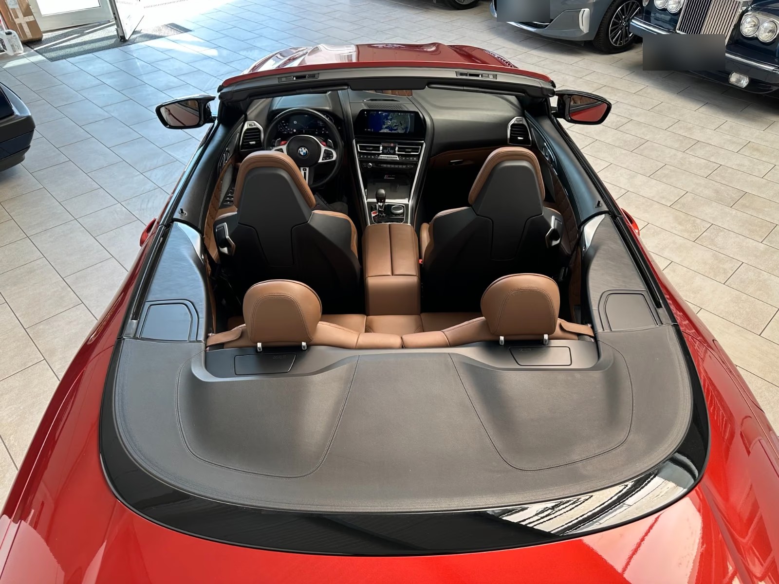 Overhead view into the cabin of the BMW M8 Cabrio showing the four cognac leather seats and centre console.