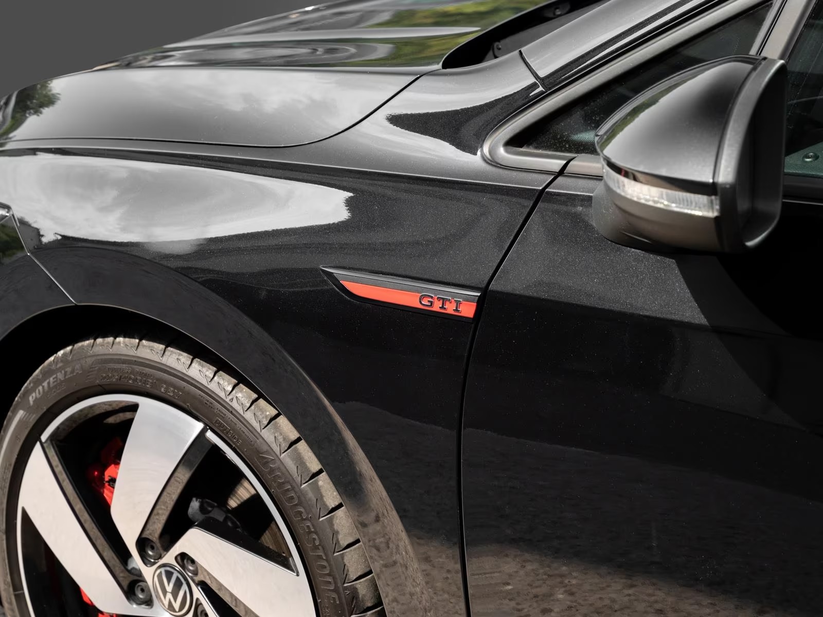 Front wing GTI badge and mirror detail of the black Golf GTI Clubsport.